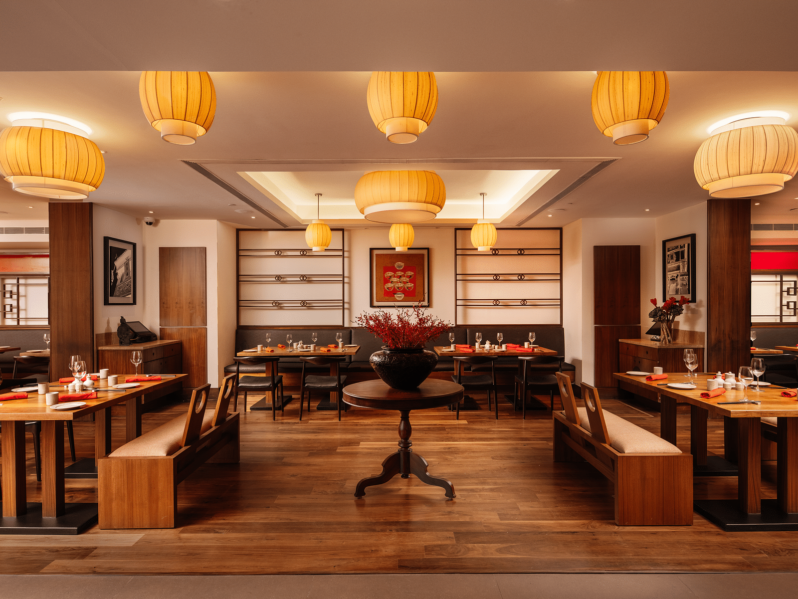 A restaurant with wooden seating arrangements and lantern hanging from the ceiling at The Raintree Hotel, St. Mary's Road.