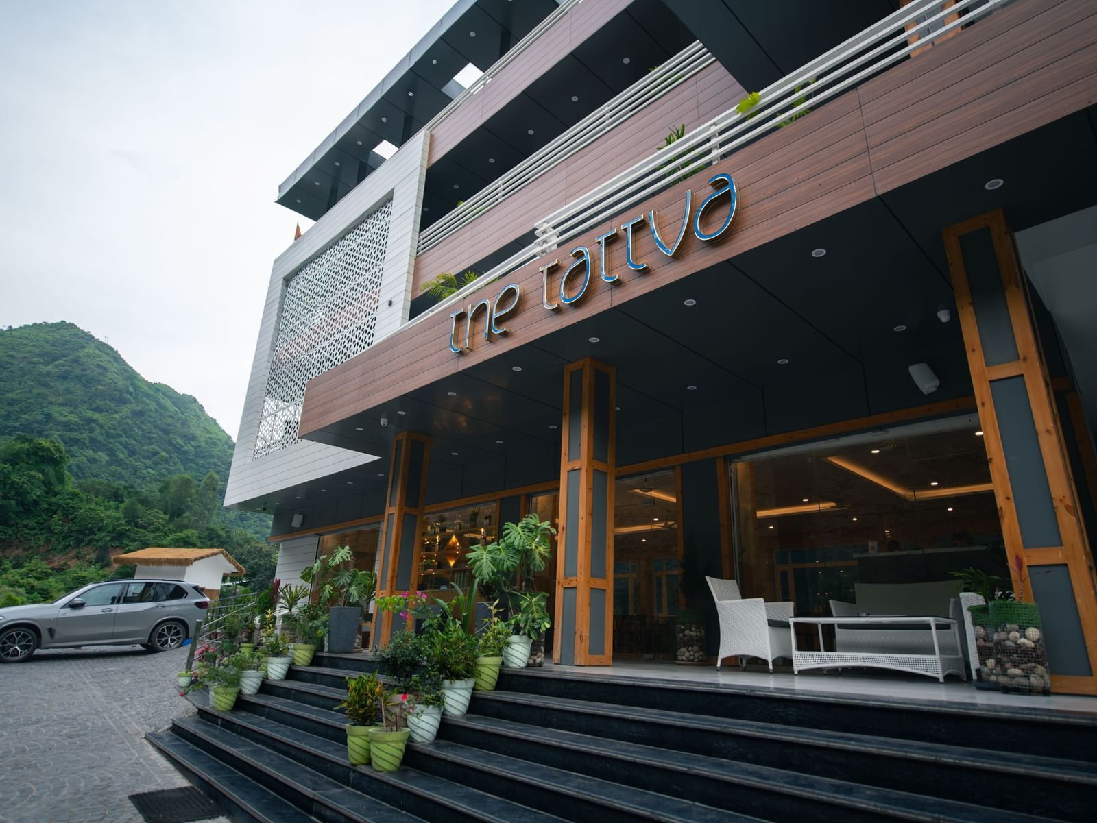 Facade of The Tattva Devaprayag hotel featuring the entrance and three floors.