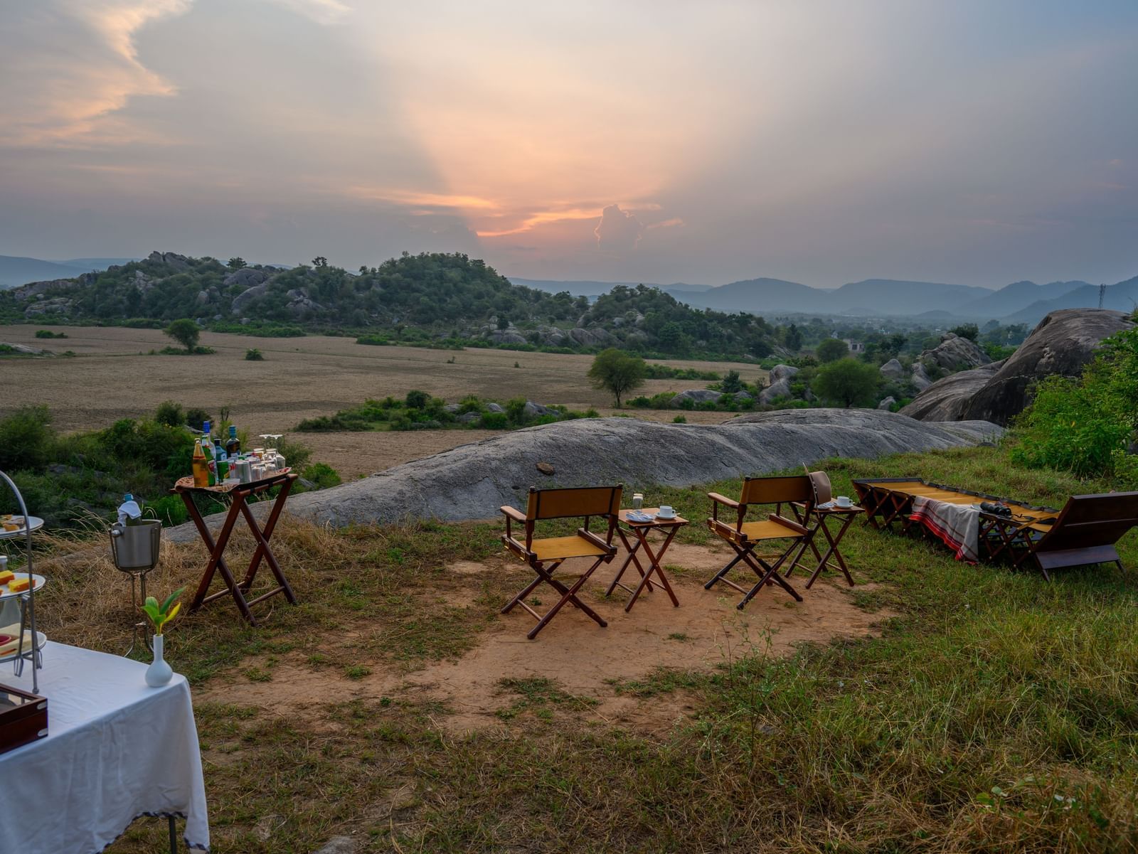 An image of an outdoor seating amidst greenery over viewing the mountains - Utsav Camp Sariska.