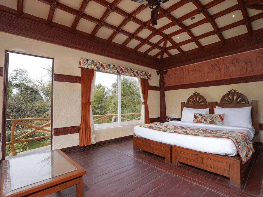 Ethnic villa offering a spacious bedroom and large windows with curtains at Summit Green Lake Tea Resort & Spa, Kaziranga