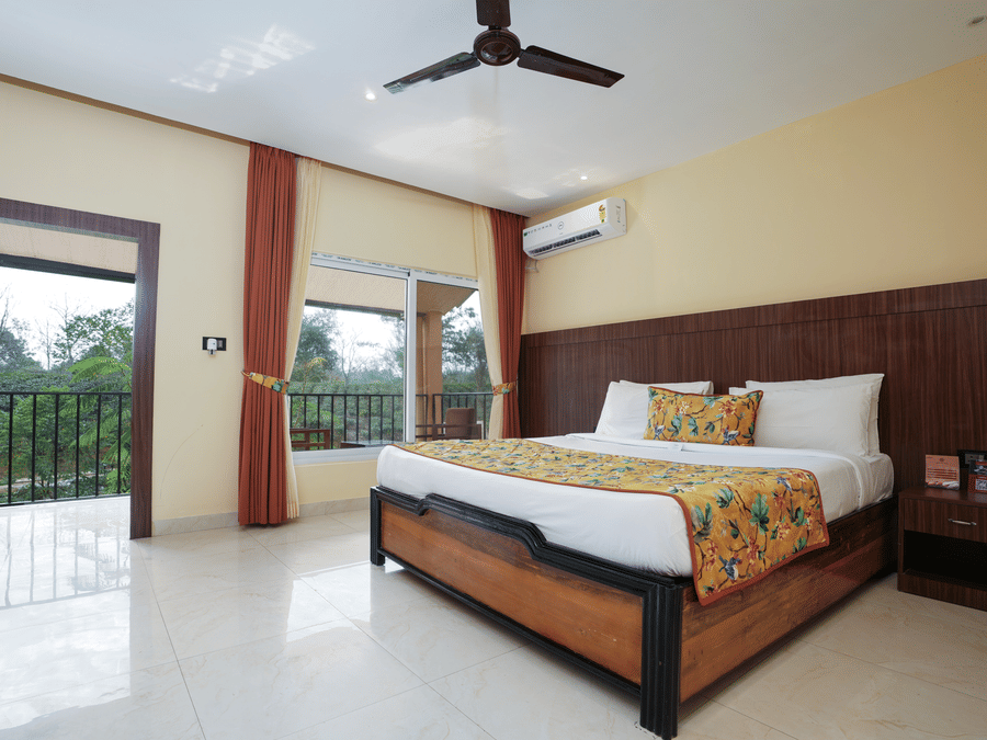 Premium room with balcony offering a nature view and spacious bed at Summit Green Lake Tea Resort & Spa, Kaziranga