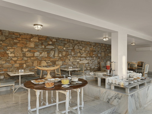 Restaurant at Fateh Safari Suites, Kumbhalgarh featuring dining tables and chairs and food counters.