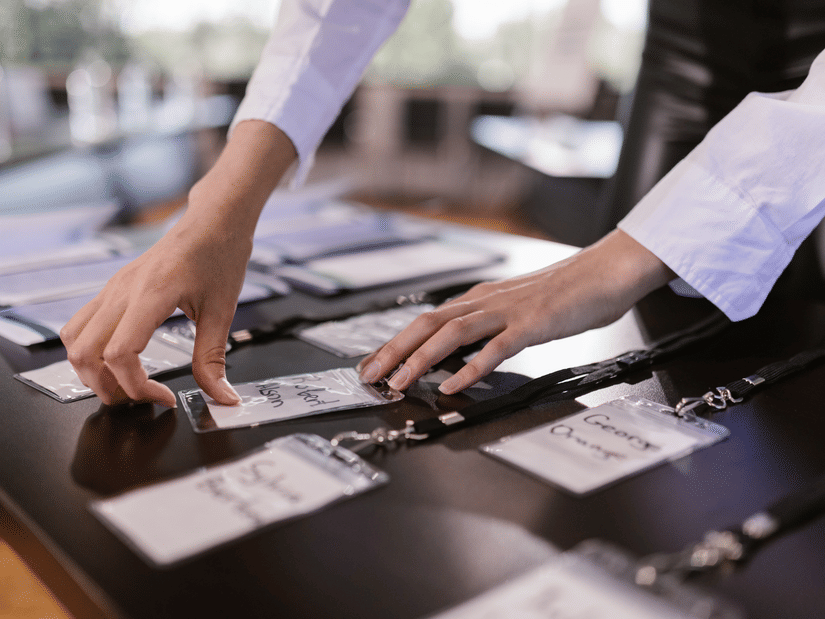 Close-up shot of the registration desk arranging name cards on the table.