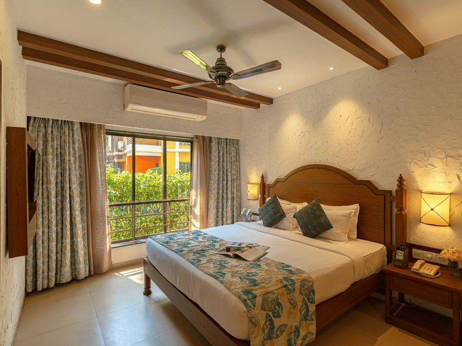 Room of a hotel with a balcony and vintage style decor.