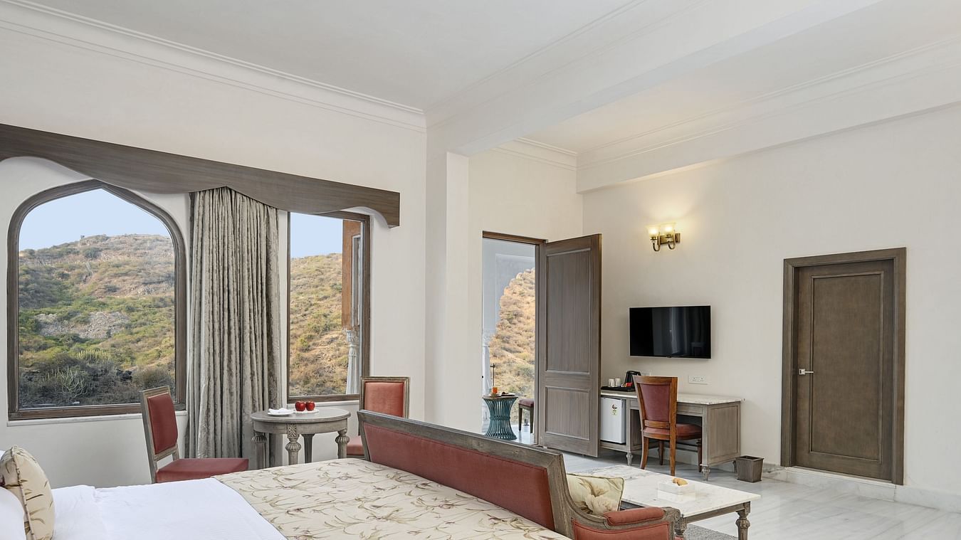 Fateh Vilas Udaipur - Interior view of the Fateh Vilas Suite featuring a king size bed a sofa and a balcony