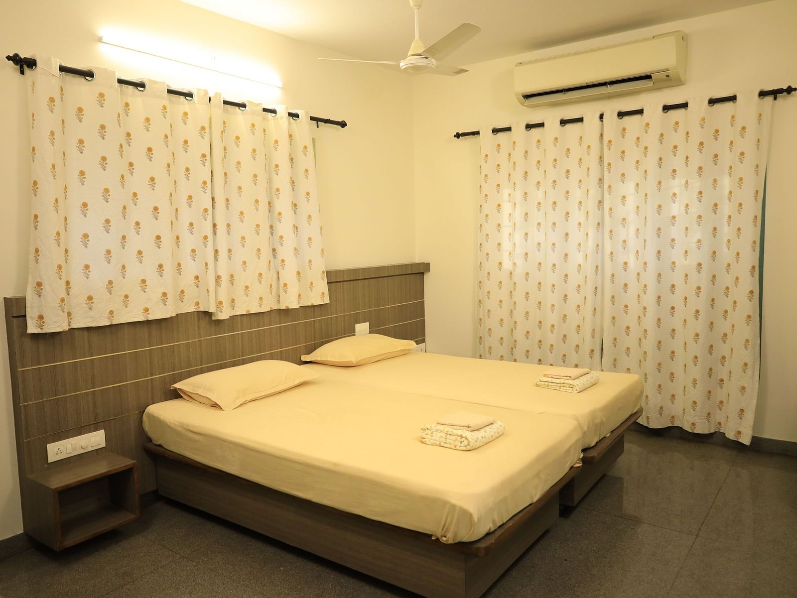 A shot of the bedroom with a bed, nightstands, and curtains.