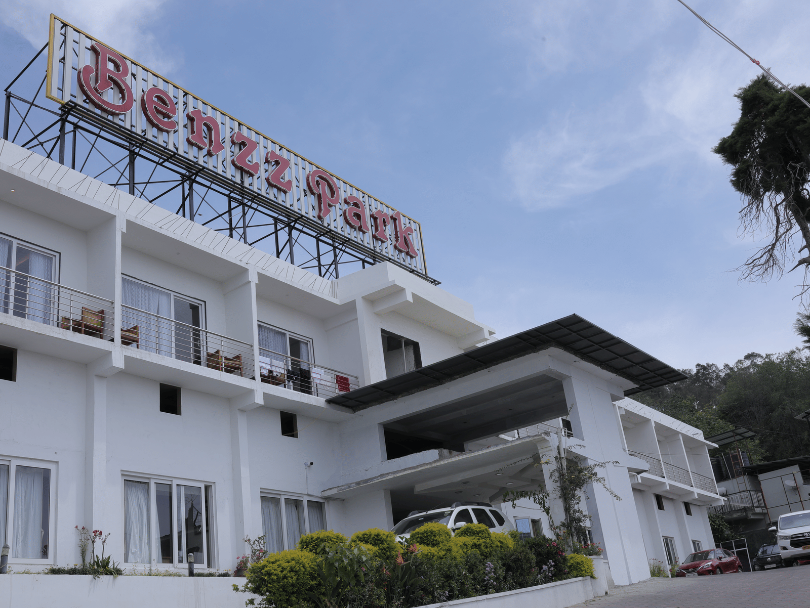The exterior of Benzz Park, Kodaikanal hotel building under a clear sky.