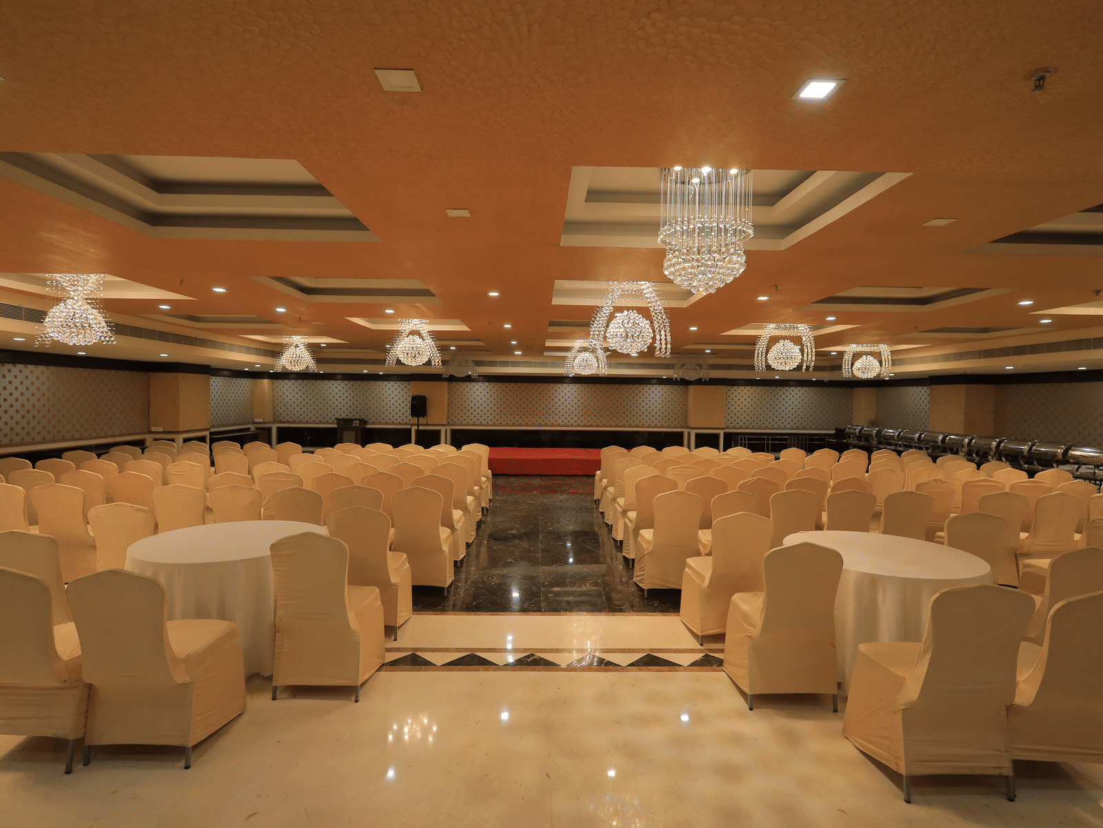A wide-angle shot of the Rovver hall at Benzz Park, Vellore, with chairs facing towards the centre stage.