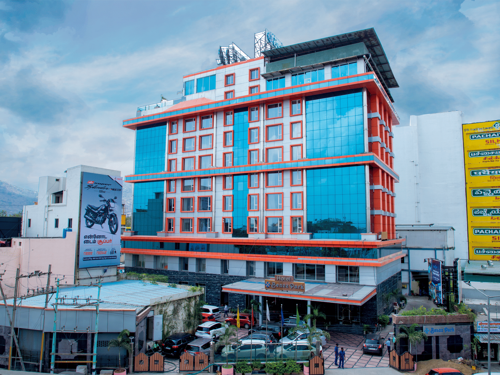 Facade shot of Benzz Park, Vellore, featuring the entrance on the bottom of the building along with a cloudy sky in the background.