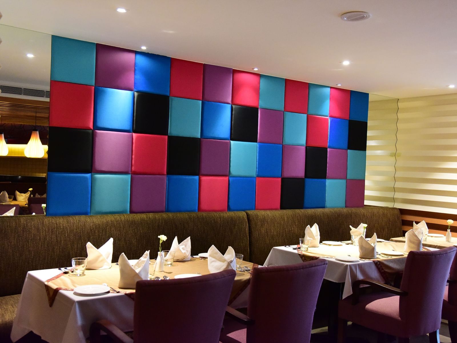 Well lit dining room at The Royal Comfort with aligned tables and chairs.