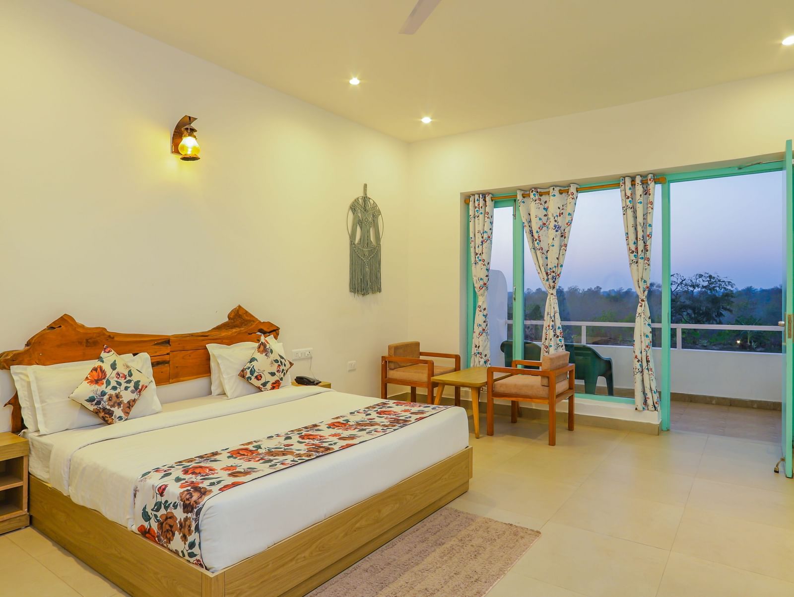 A cosy bedroom at Vedikant Resorts The Mallard Corbett includes a bed, chairs, and a view through the balcony.
