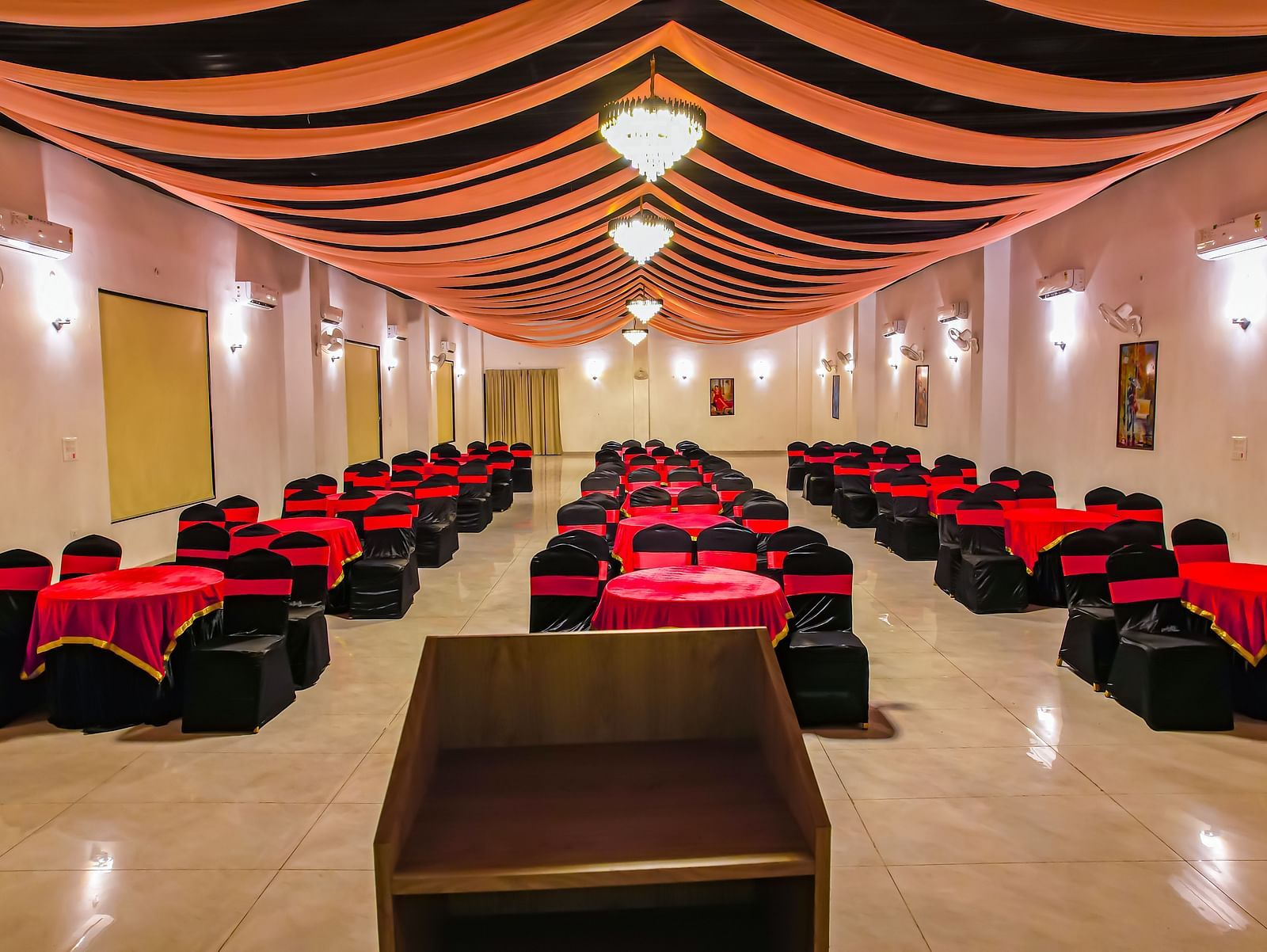 Another view of an empty banquet hall at Vedikant Resorts The Mallard Corbett displays rows of chairs and tables under a decorated ceiling.