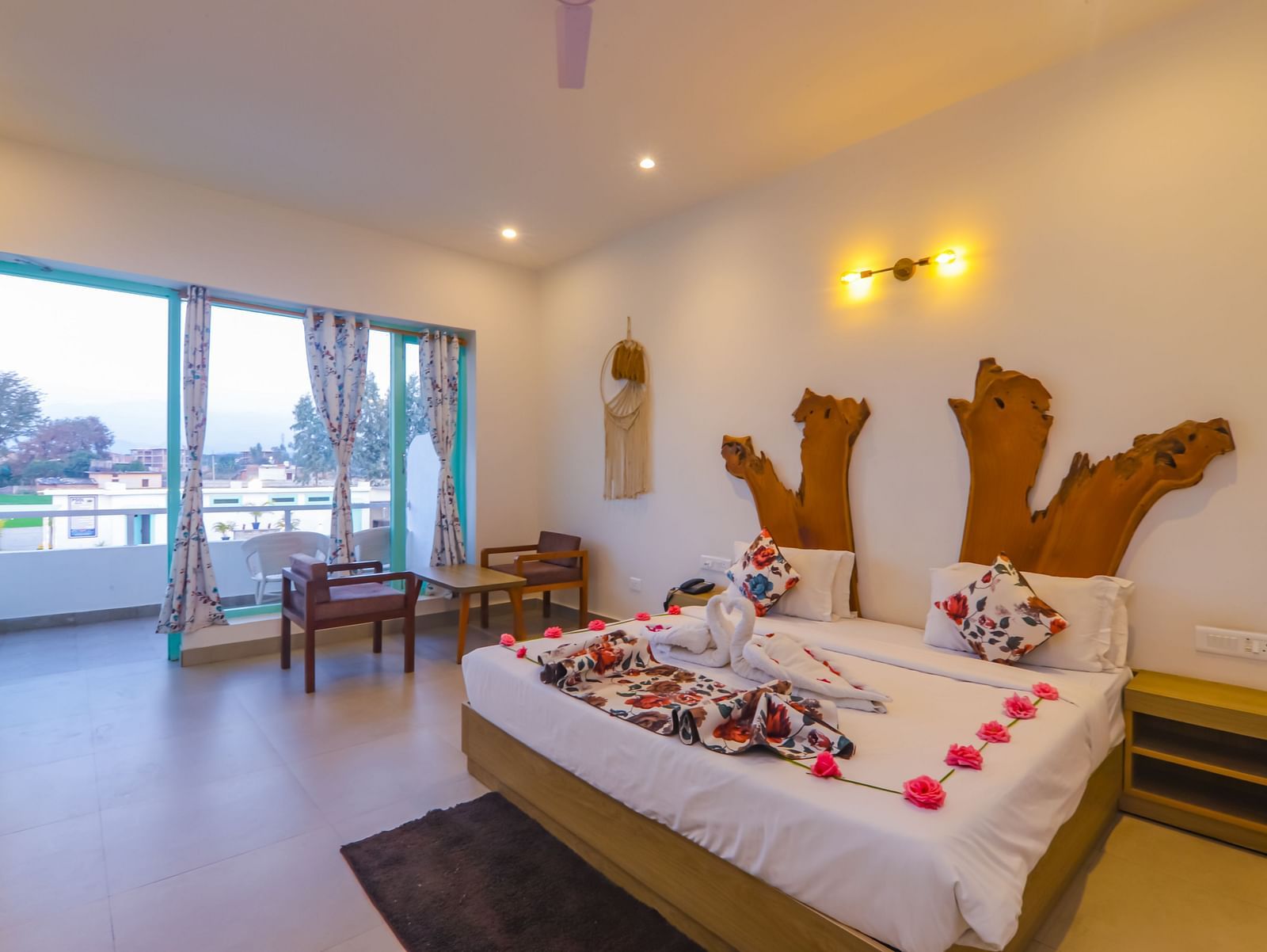 A uniquely decorated bedroom at Vedikant Resorts The Mallard Corbett features a bed adorned with flowers and seating.