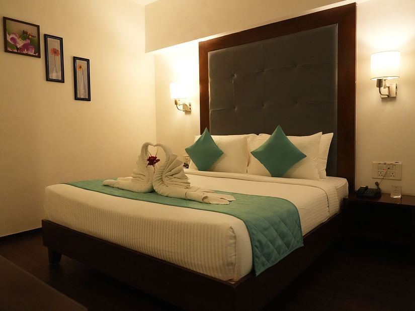 Side view of Suite room featuring a cosy bed with two lights on each side at Clarks Collection, Bhavnagar