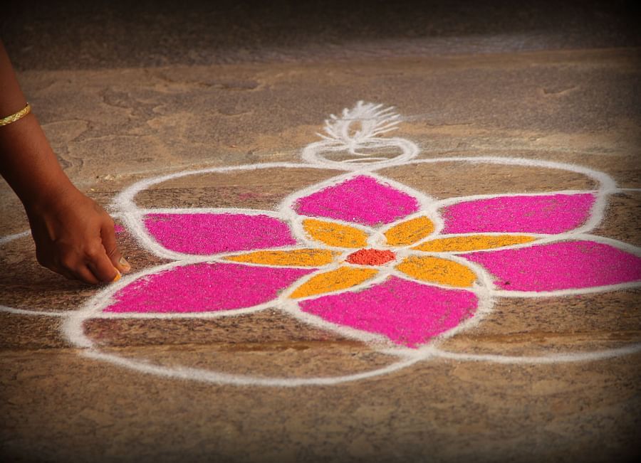 alt-text A person preparing rangoli at Chidambara Vilas