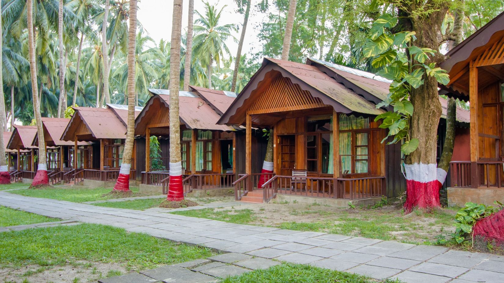 Many rows of rooms next to a paved stone pathway in a luxury resort in havelock