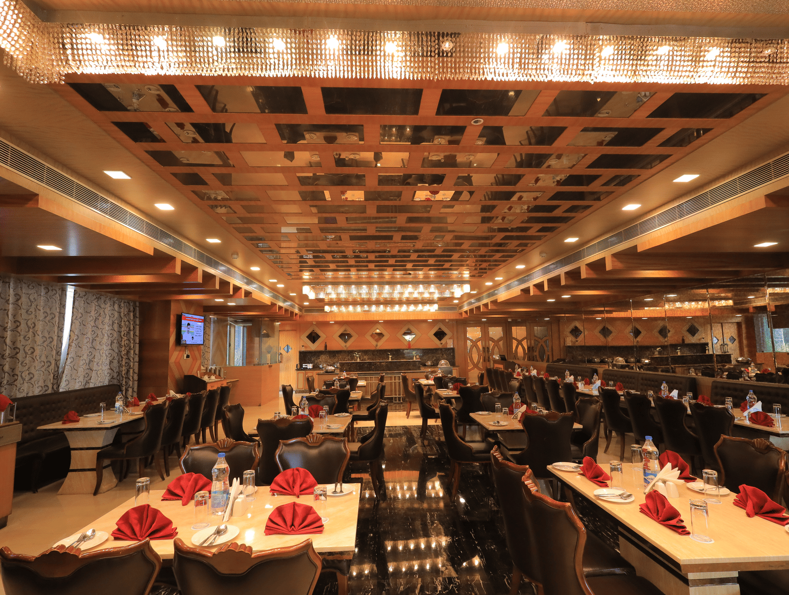 Full view of the Porchae multi-cuisine restaurant with warm lighting and well-arranged dining tables at Benzz Park, Vellore.
