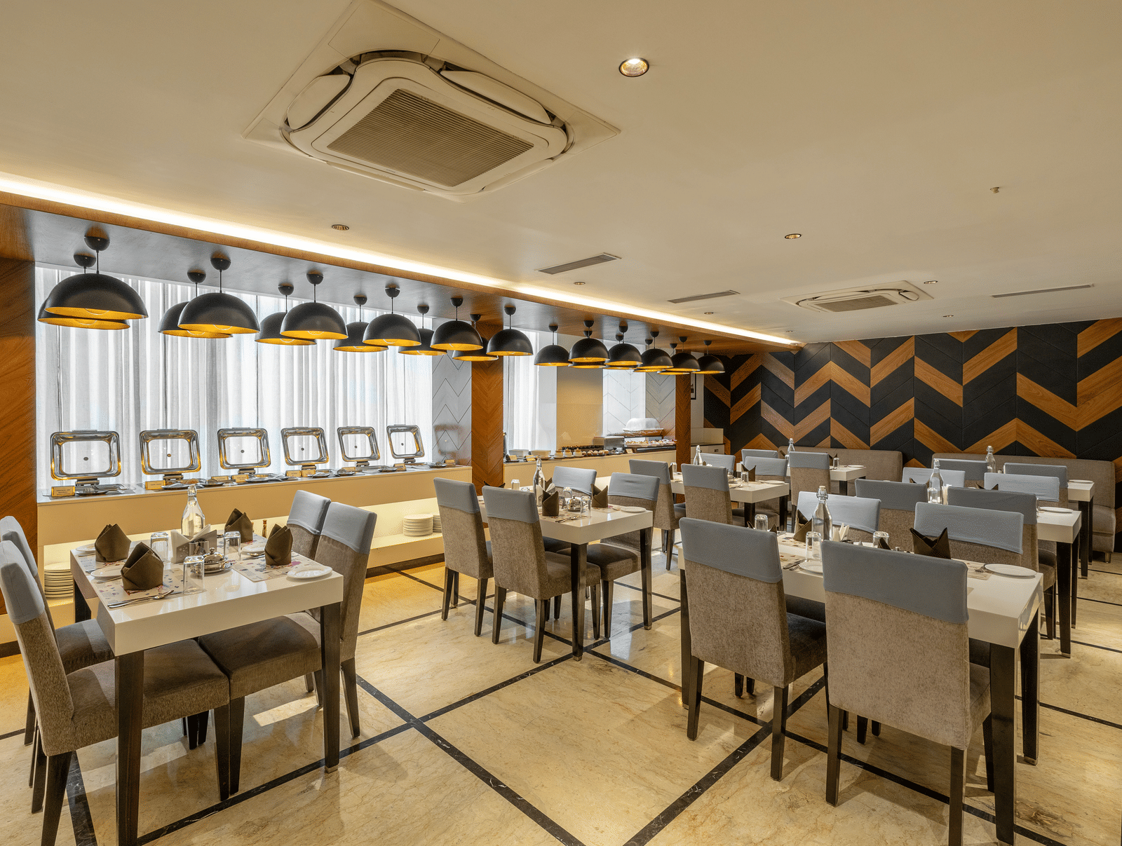 A wide view of the dining area in the Citrine Hotel, featuring neatly arranged tables and chairs.