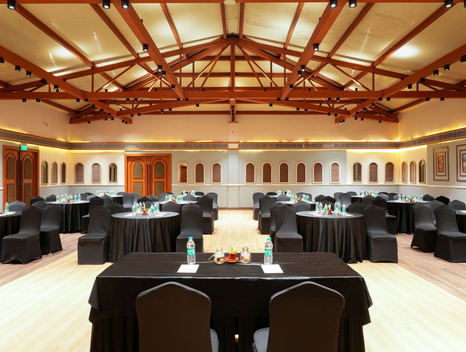 OM I with exposed timber ceiling and round tables at Vedic Village Spa Resort.