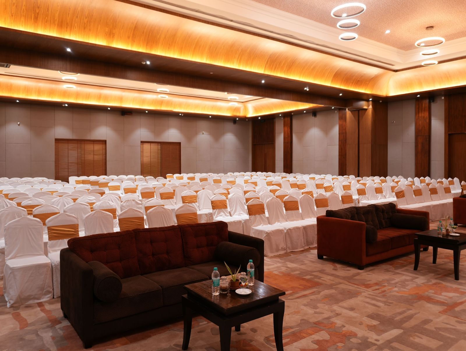 Utsav Convention centre  with white chair covers and lounge seating at Vedic Village Spa Resort.