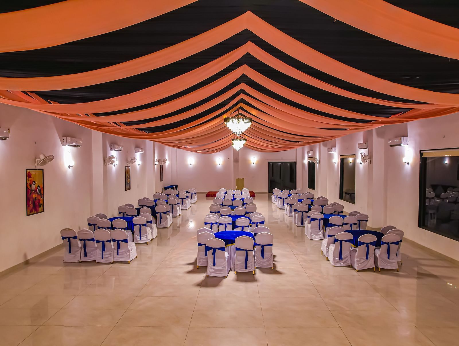 An indoor dining area at Vedikant Resorts The Mallard Corbett features tables and chairs under a decorated ceiling with lighting.