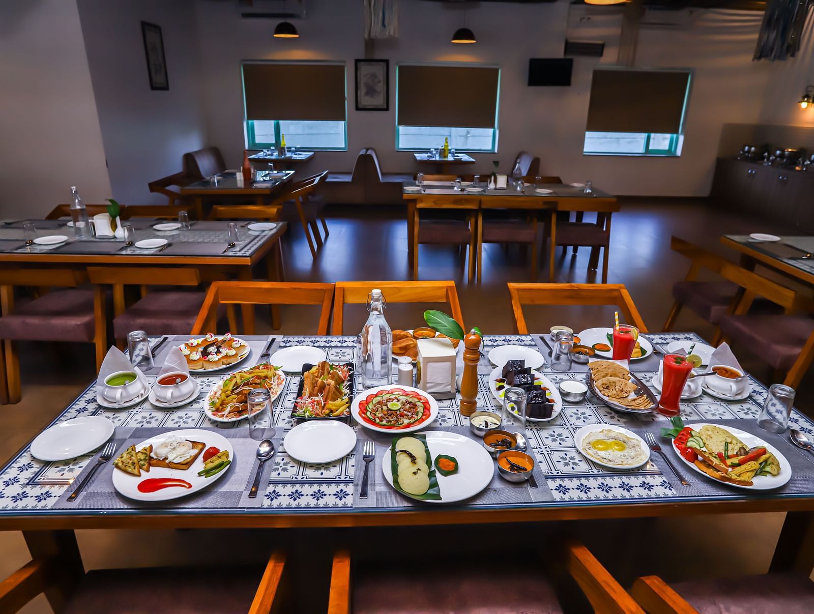A dining area at Vedikant Resorts The Mallard Corbett features set tables and chairs in a brightly lit space.