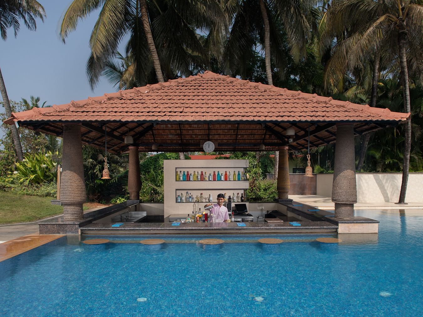 Our pool-side cafe in South Goa, Aquarius, looks dream-like as it resembles a gazebo coming out of the pool in a lush green backdrop