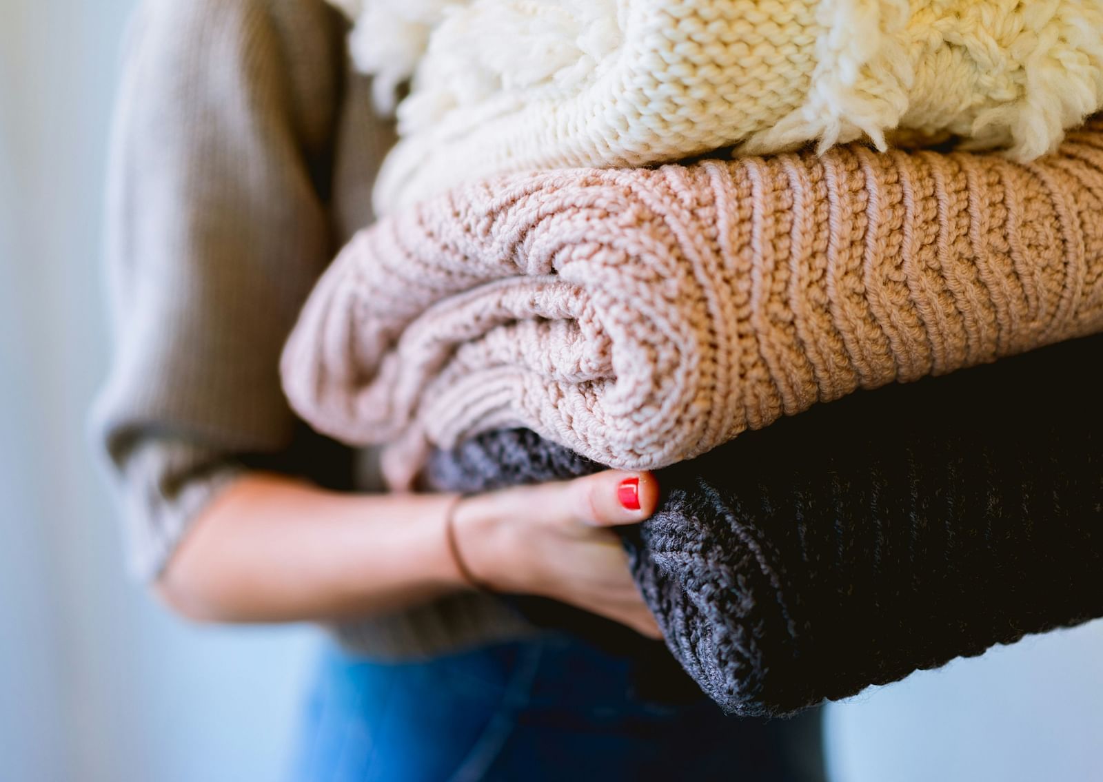Person carrying neatly folded clothes, symbolizing cleanliness and organization