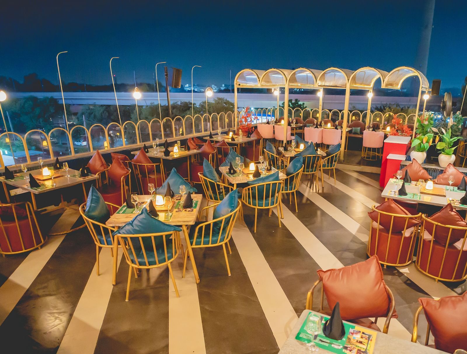 An image of a rooftop restaurant with several chairs and tables at Themis Barbecue House, NSP Pitampura