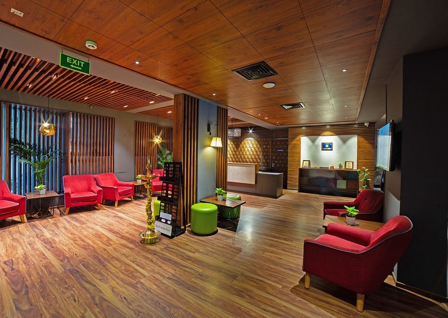 A spacious and inviting lounge area at Icon Boutique Hotel by Bhagini, Domlur, with comfortable seating, wooden flooring, and a warm ambiance.