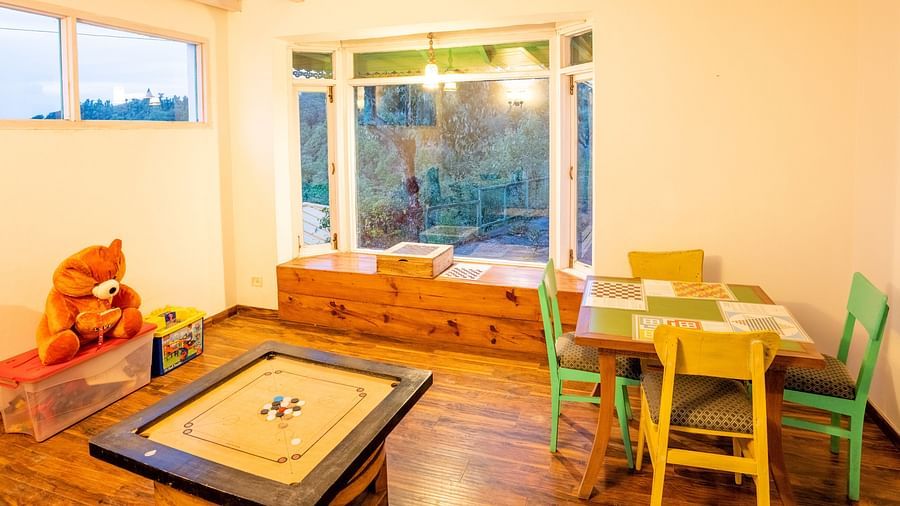 indoor game room with windows at Te Aroha By Shervani, Mukteshwar