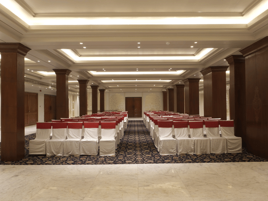 The Swarn Mahal with theatre-style seating, wooden columns, ambient lighting, and spacious interiors prepared for wedding functions and social events | Clarks Amer, Jaipur