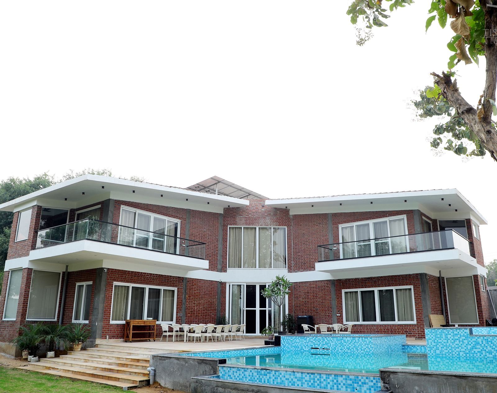 Facade image of Tisya Farms, Gurgaon surrounded by lush greenery.