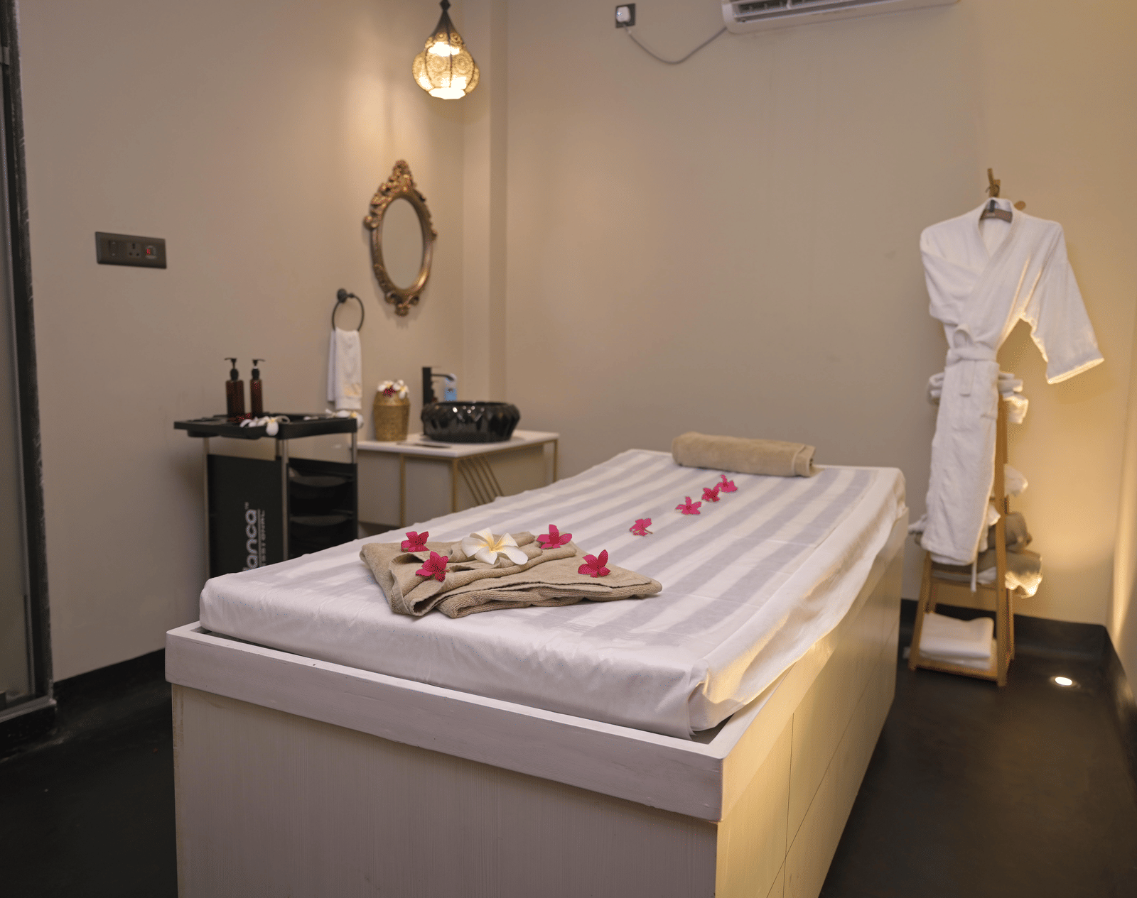 A spa room with a neatly arranged massage bed and treatment essentials at Hotel Sonar Bangla Mayapur.