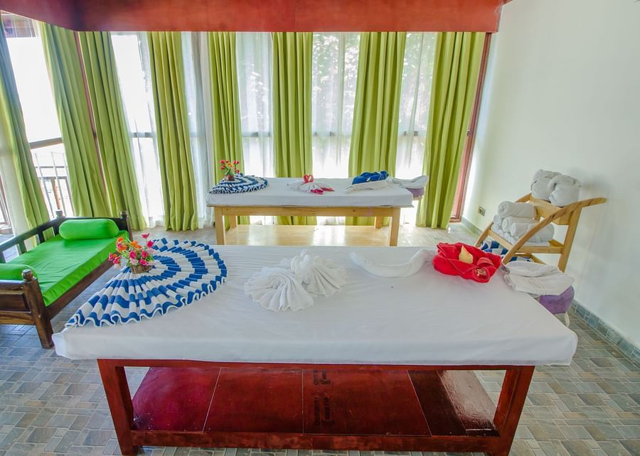 A massage table inside Neil Ocean Spa with a sofa on the side - Symphony Summer Sand Beach Resort And Spa, Neil island