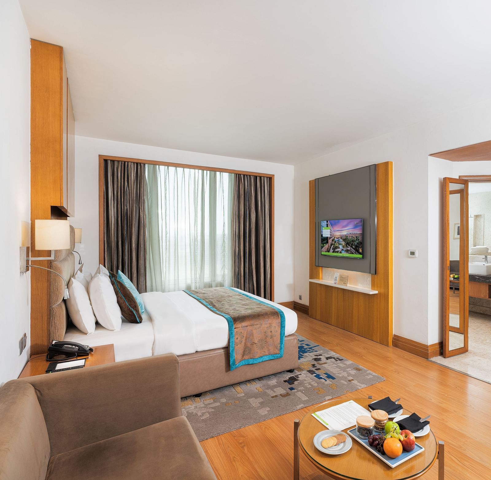 Elegantly furnished executive room featuring a comfortable seating area, work desk, and ample natural light - Nirvana Luxury Hotel, Ludhiana