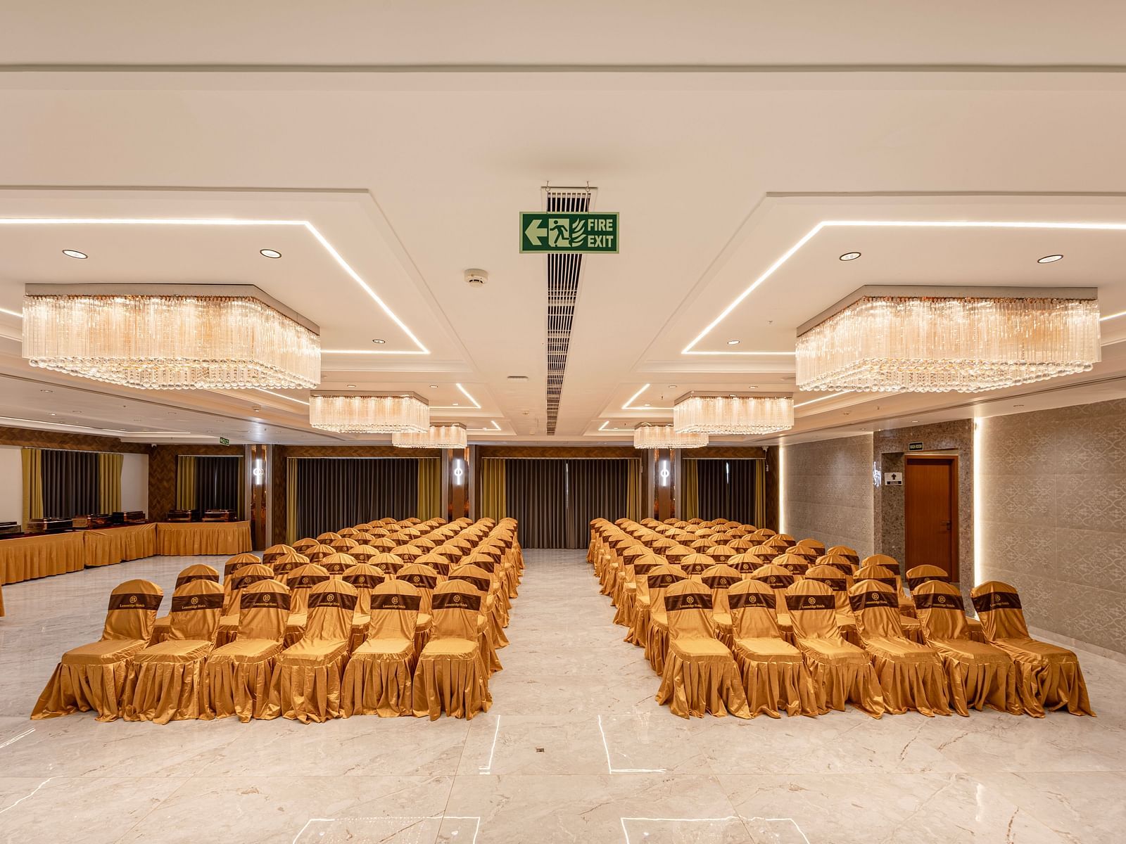 Banquet hall setup with golden chairs and chandeliers at Lemonridge Hotels, IDPL Balanagar.