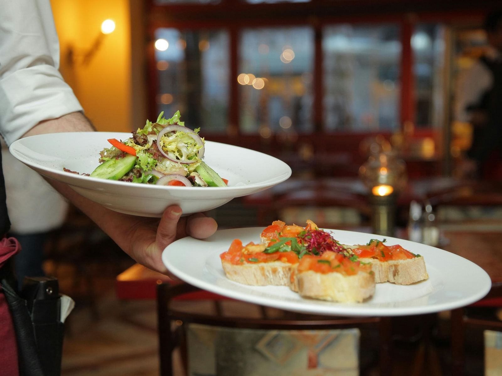 A server handing out two trays filled with tasty food