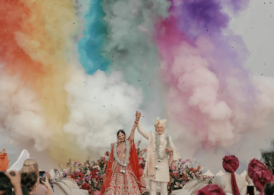 A newly wedded couple celebrating their wedding with colours flying around.
