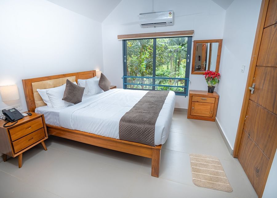 alt-text Side view of room with wooden door, window and modern amenities at Feel Free Retreat, Wayanad