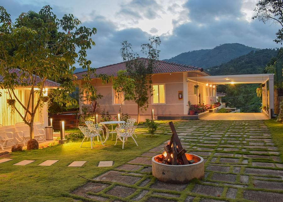 campfire in front of a room next to a garden at Ibex Stays & Trails, Kotagiri