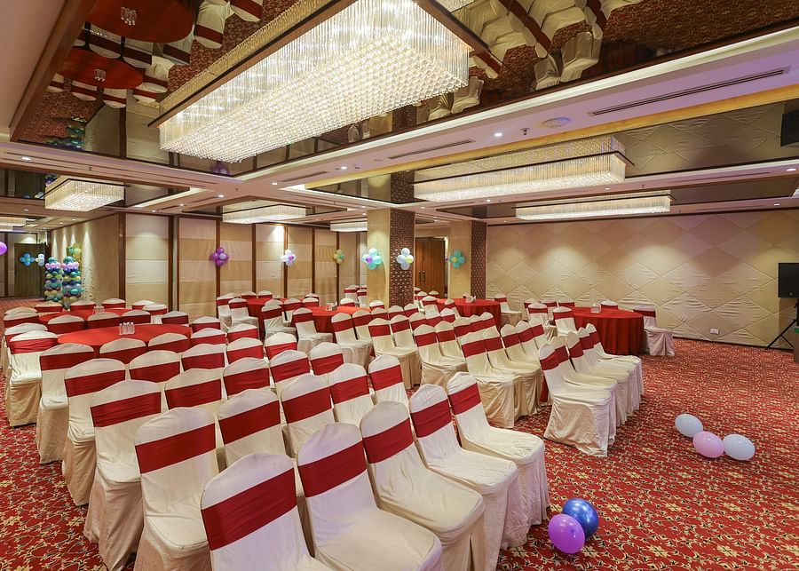 Blossom Hall with stylish decor, lights, and chairs at Icon Premier Hotel by Bhagini, Devarabisanahalli