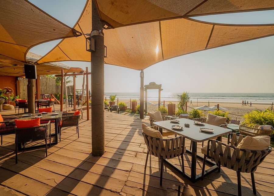alt-text full angle view of restaurant designed with wooden interior with posh decor facing the beach