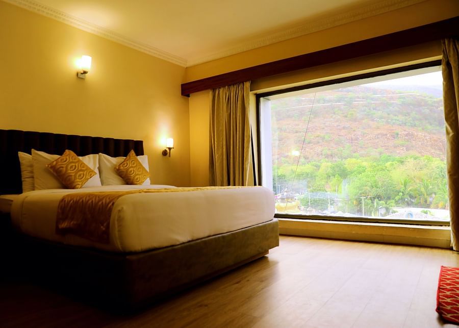 Bedroom with large window and mountain view.