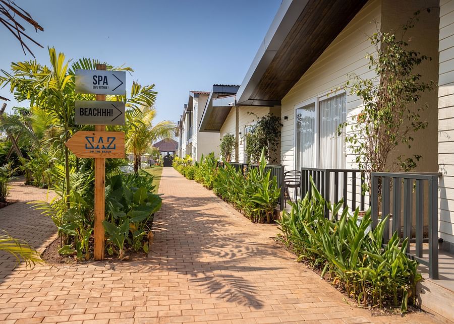 exterior image of sibaya beach resort, morjim beach with a pathway leading to all the cottages and signboard in the middle