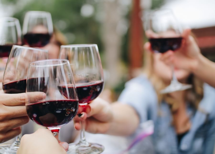 A group of people holding a glass of red wine and toasting at The Retreat Hotel and Convention Centre, Madh Island, Mumbai