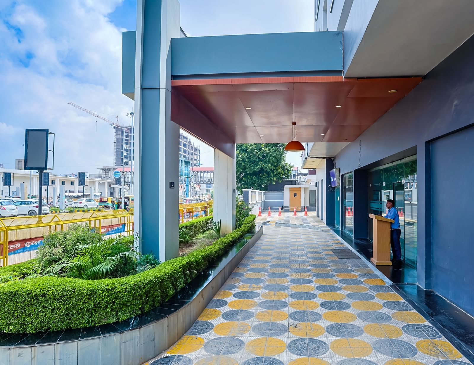 Entrance walkway with patterned tiles and greenery at Max Hotel Prayagraj.