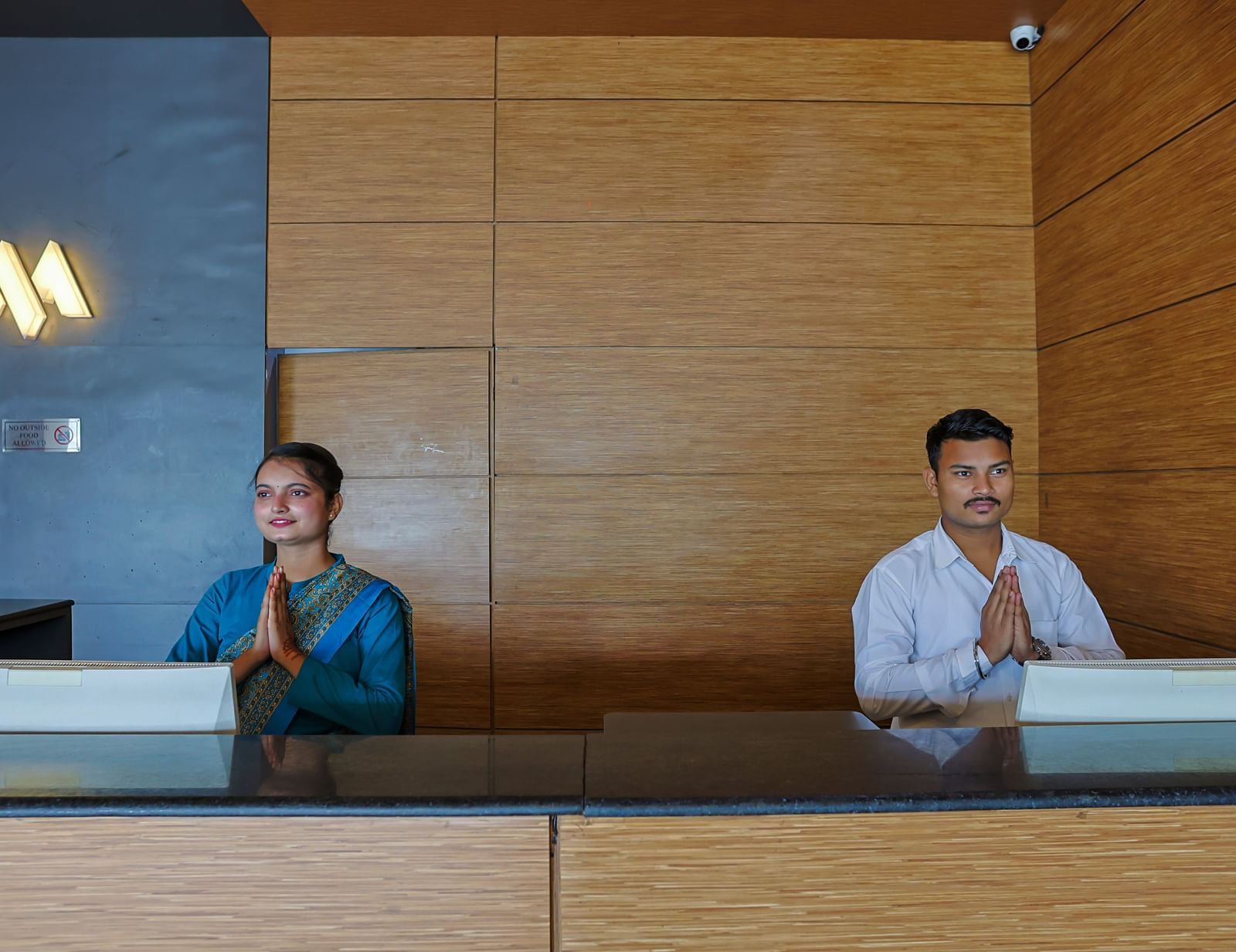 Reception desk with staff members at Max Hotel Prayagraj.