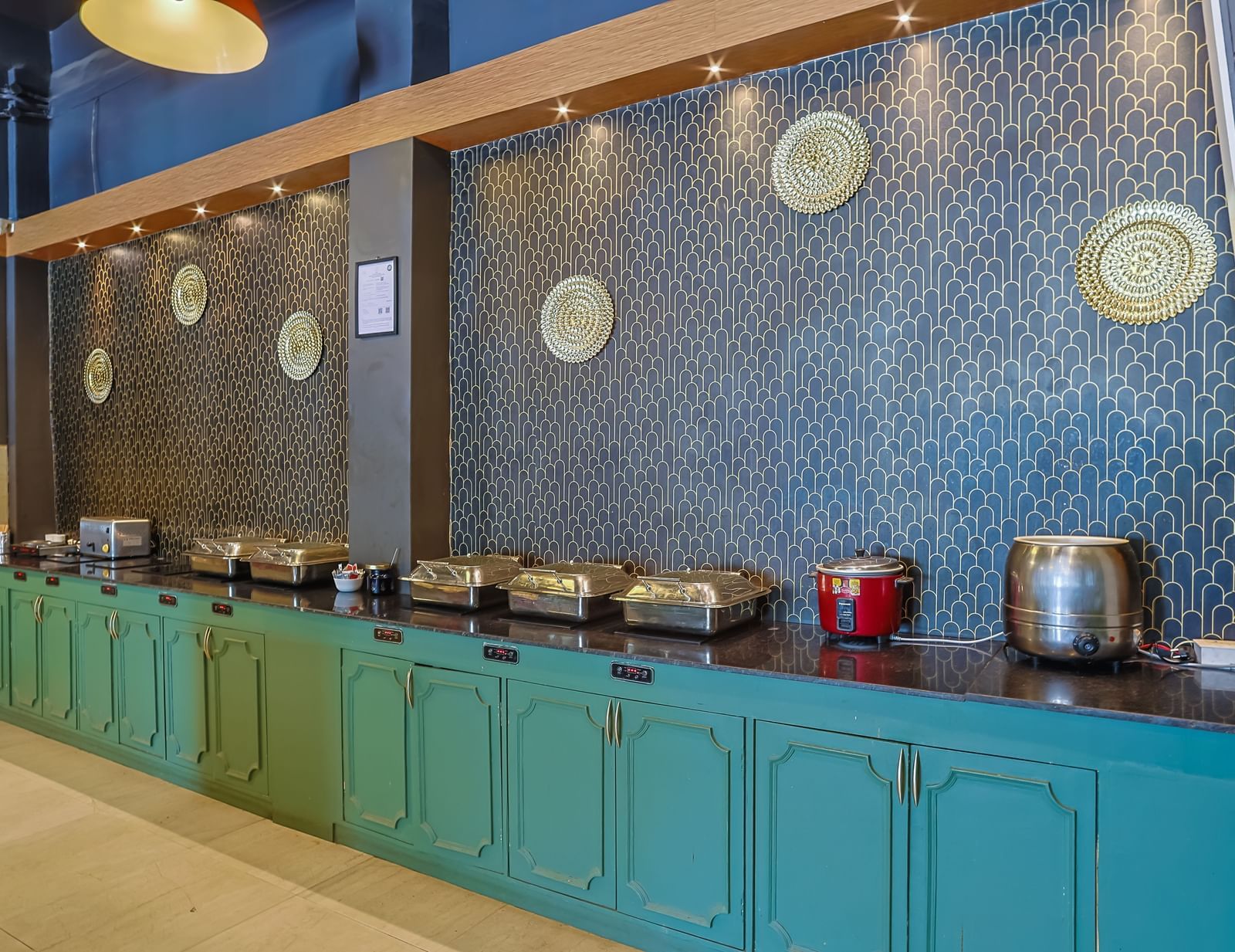 Buffet setup with utensils, chafing dishes and counters at Max Hotel Prayagraj.