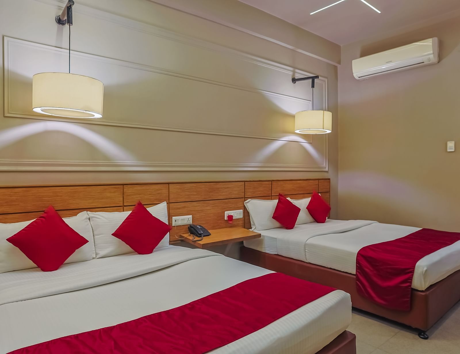 Neat hotel room with twin beds and wall decor at Max Hotel Prayagraj.